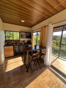 a kitchen with a table and chairs in a room at La cabaña del Colibrí in Bijagua