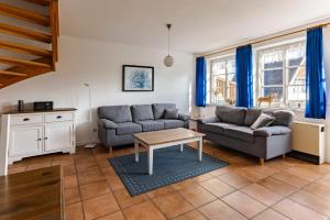 a living room with two couches and a table at Friesenhof am Deich in Nordstrand