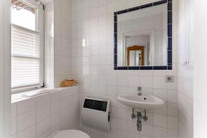 a white bathroom with a sink and a mirror at Friesenhof am Deich in Nordstrand