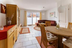 a kitchen and living room with a table and chairs at Haus am Kurhaus 9 in Nordstrand