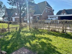 a yard with a fence and a house at Haus am Kurhaus 9 in Nordstrand
