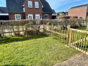 a wooden fence in front of a house at Haus am Kurhaus 9 in Nordstrand