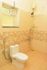 a bathroom with a toilet and a shower at Skandavanam in Tiruvallūr