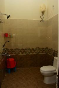 a bathroom with a toilet and a bath tub at Skandavanam in Tiruvallūr