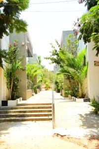 a street with stairs and trees and buildings at Skandavanam in Tiruvallūr