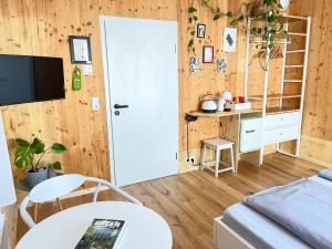 a living room with a white door and a table at Hacienda Rooms - moderne Zimmer in ruhiger Lage - Room only ! in Friedrichshafen