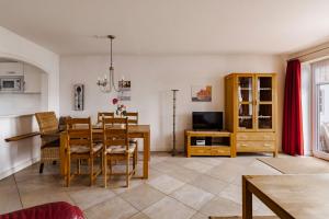 a living room with a dining room table and a television at Haus im Halligweg 18 in Nordstrand