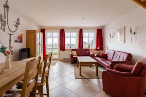 a living room with red furniture and red curtains at Haus im Halligweg 18 in Nordstrand