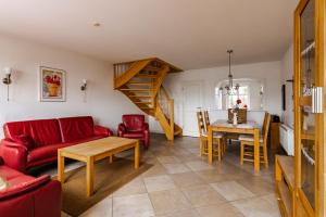 a living room with a red couch and a table at Haus im Halligweg 18 in Nordstrand