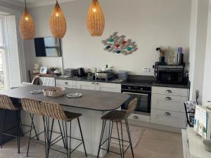 a kitchen with a table and some chairs in it at Sunrise Apartment in Weymouth