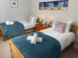 a bedroom with two beds with towels on them at Sunrise Apartment in Weymouth