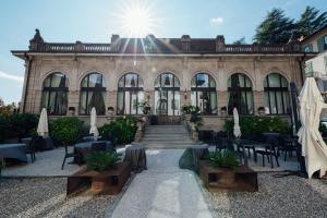 a building with tables and chairs in front of it at Hotel Bigio in San Pellegrino Terme