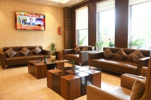 a living room with couches and tables and a tv at Hotel The Vilana A Unit of JG Developers Rishikesh in Rishīkesh