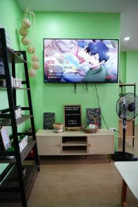 a living room with a tv on a green wall at Mountain and Sunsetview Baguio Residences in Baguio