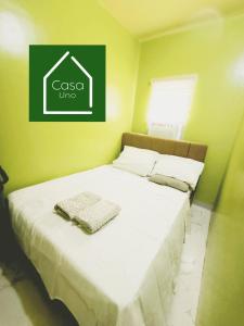 a bed in a room with a sign on the wall at Casa Uno Leyte in Palo +3 photos