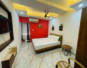 a bedroom with a bed and a red wall at JK Residency in Kunnamangalam