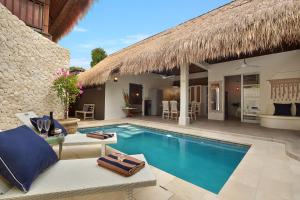 a villa with a swimming pool and a resort at Villa Elleo in Seminyak