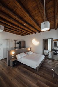a bedroom with a large bed and a wooden ceiling at Hotel Bigio in San Pellegrino Terme