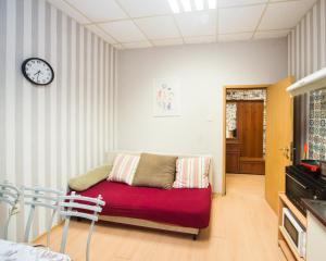 a living room with a couch and a clock on the wall at Basic Apartment for up to 5 guests in Burgas +15 photos