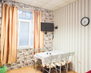 a dining room with a table and chairs and a clock at Basic Apartment for up to 5 guests in Burgas
