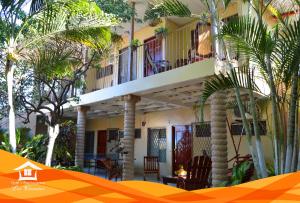 a building with palm trees in front of it at Hotel y Apartments Los Cisneros in Managua