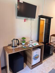 a wooden desk with a tv on a wall at Restora Ella in Ella
