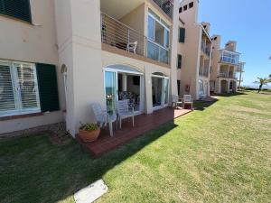 a house with a deck with chairs on it at Unobstructed sea view gem (1 Spindrift) in St Francis Bay