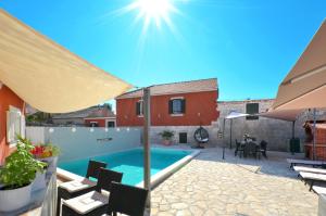 a backyard with a swimming pool and a house at Islander house with pool in Trogir