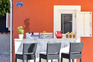 a table and two chairs in front of a building at Islander house with pool in Trogir