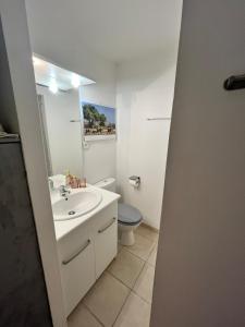 a white bathroom with a sink and a toilet at Charming studio in a residence in Provence in Graveson