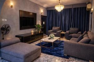 a living room with two couches and a tv at Luxury 6 bedroom villa in independence layout 247 power parking and Wifi in Enugu