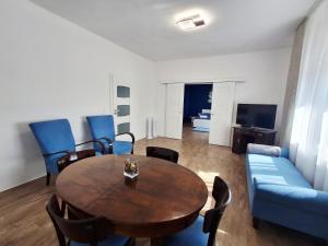 a living room with a table and a blue couch at SZEDERMÁLNA Vendégház in Sárospatak