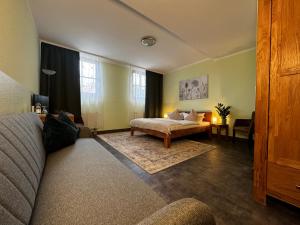 a living room with a bed and a couch at Logis Hotel Stadt Neustadt in Neustadt