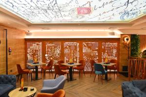 a restaurant with tables and chairs and a mural at Hotel Central in Inđija