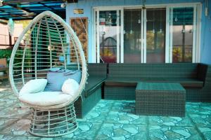 a wicker chair with a pillow in front of a porch at Mountain and Sunsetview Baguio Residences in Baguio