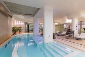 a large swimming pool in a hotel lobby at DoubleTree by Hilton Florence Metropole in Florence