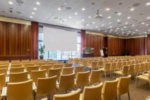 a large room with chairs and a podium in it at DoubleTree by Hilton Florence Metropole in Florence +59 photos
