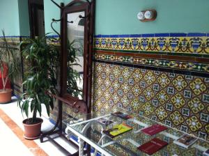 Habitación con azulejos de colores en la pared y espejo. en Pensión España en Cádiz