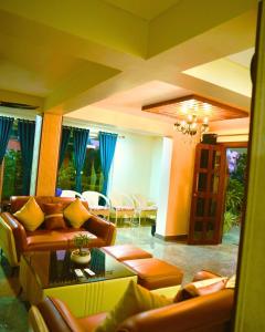 a living room with couches and a table and chairs at Pine Tree Resort Betla in Kechki