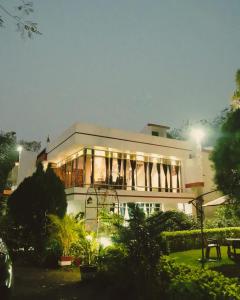 a large white building with a lot of windows at Pine Tree Resort Betla in Kechki