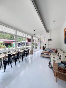 a living room with a couch and a table and chairs at Bingo Hostel Khao Sok in Khao Sok National Park