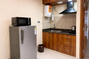 a kitchen with a stainless steel refrigerator and a microwave at Nova Regency in Bangalore +31 photos