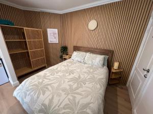 a bedroom with a bed with a tropical print wall at Lakeside Riverfront Yamba 1-2 Small Pet Friendly in Yamba