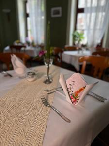 a table with a white table cloth and fork and napkin at Logis Hotel Stadt Neustadt in Neustadt