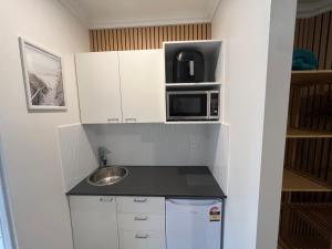 a small kitchen with a sink and a microwave at Lakeside Riverfront Yamba 1-2 Small Pet Friendly in Yamba