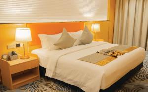 a hotel room with a large bed with white sheets at Wisney Hotel in Sihanoukville