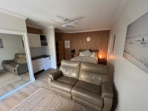 a living room with a couch and a bed and a mirror at Lakeside Riverfront Yamba 1-2 Small Pet Friendly in Yamba