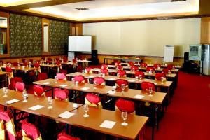 a large room with tables and red chairs at Grand Royal BIL Hotel in Praya