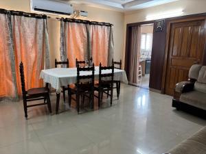a dining room with a white table and chairs at Satya Residency in Kākināda +5 photos