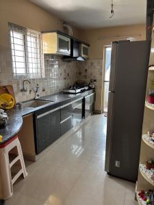 a kitchen with a stainless steel refrigerator and a sink at Satya Residency in Kākināda